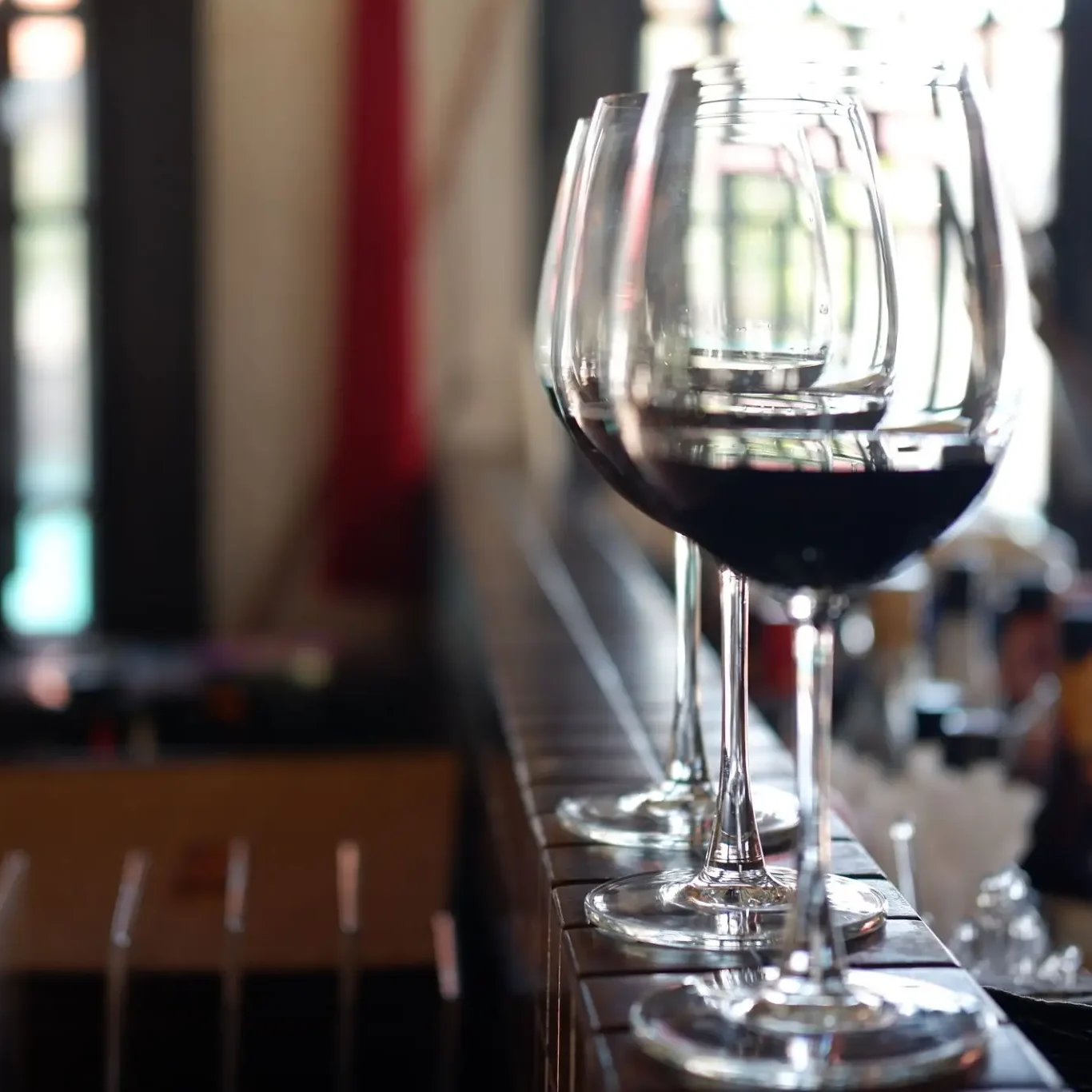 Row of red wine glasses on bar